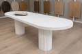Small white oval dining table with ripple pillars
